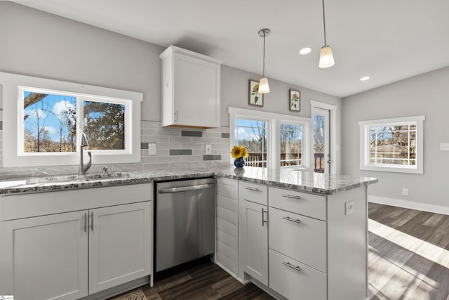 kitchen featuring light stone counters, white cabinets, pendant lighting, and dishwasher