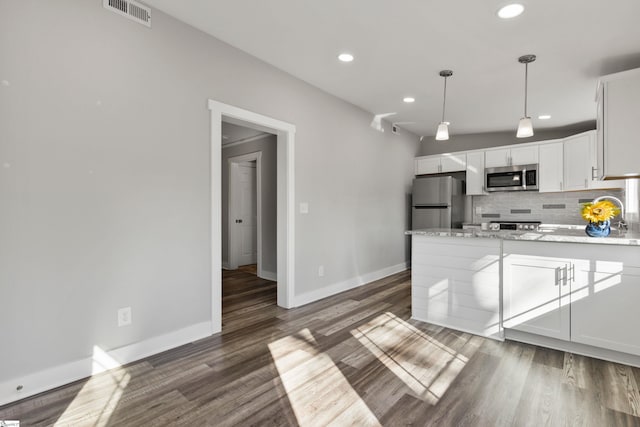 kitchen with dark hardwood / wood-style floors, decorative light fixtures, tasteful backsplash, white cabinets, and stainless steel appliances