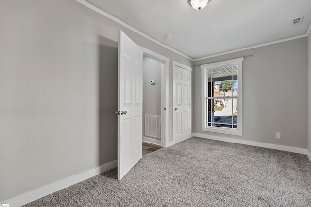 unfurnished bedroom with ornamental molding, carpet, and a closet