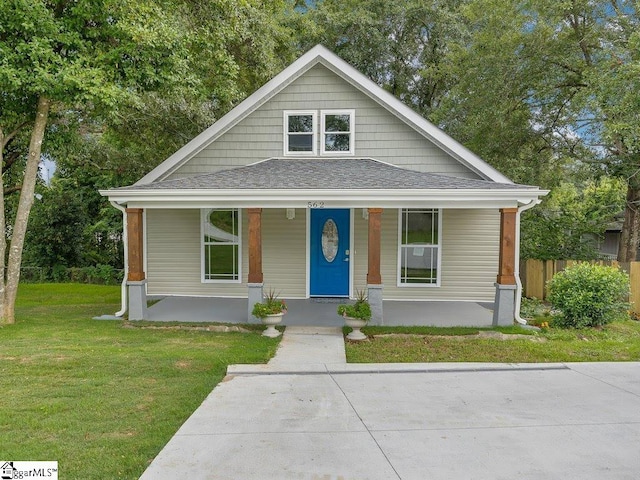 bungalow featuring covered porch and a front yard