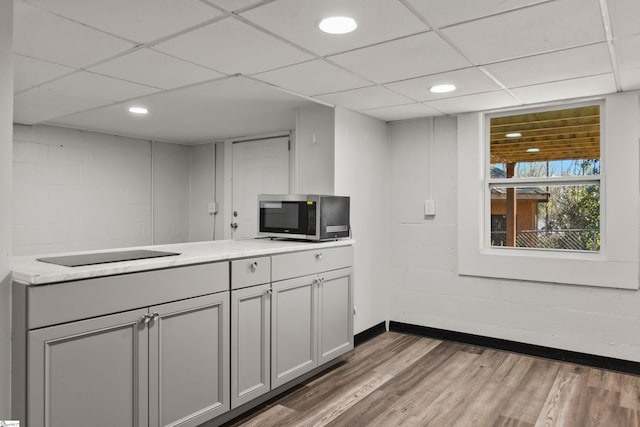 kitchen with a paneled ceiling, dark hardwood / wood-style floors, and black electric stovetop