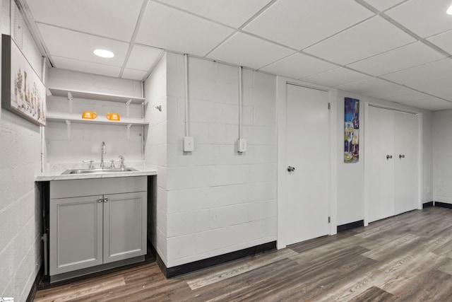 bar featuring dark hardwood / wood-style flooring, sink, gray cabinets, and a drop ceiling