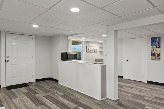 kitchen with white cabinets, wood-type flooring, and a drop ceiling