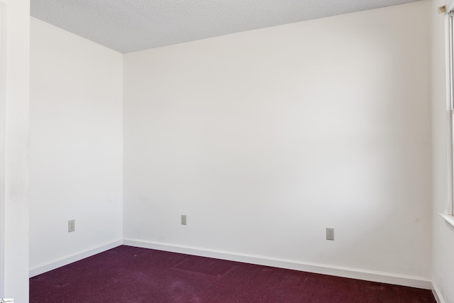 carpeted empty room with a textured ceiling