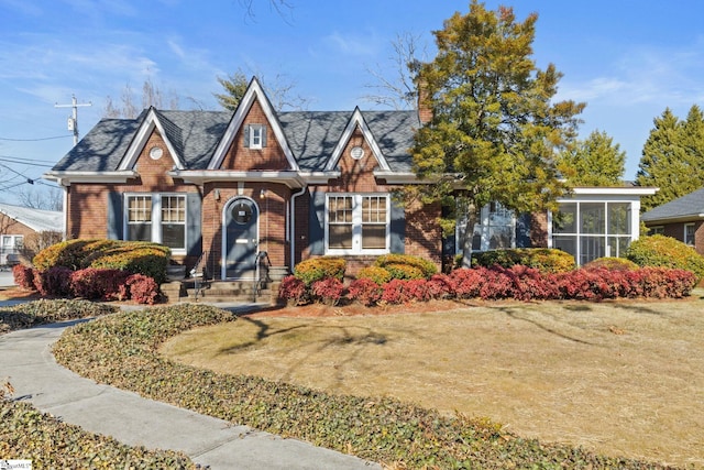 view of front facade with a front lawn and a sunroom