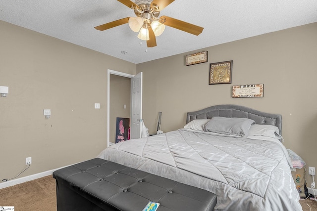 bedroom with ceiling fan, carpet, and a textured ceiling