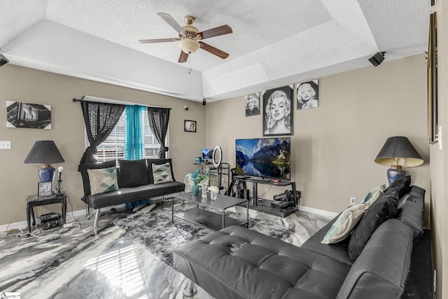 living room with ceiling fan, a tray ceiling, vaulted ceiling, and a textured ceiling