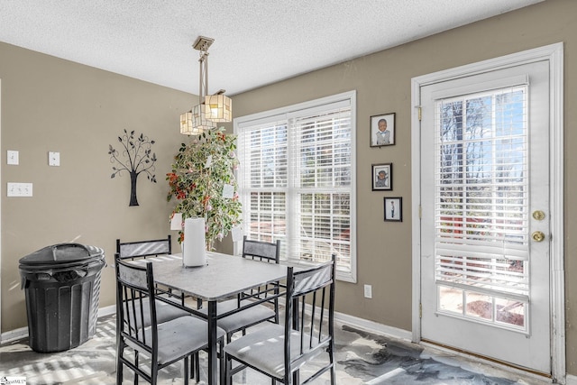 dining space featuring a healthy amount of sunlight and a textured ceiling