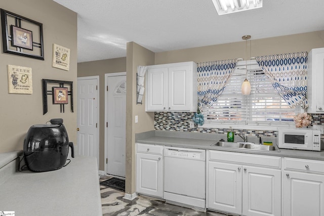 kitchen featuring white cabinetry, sink, white appliances, and hanging light fixtures