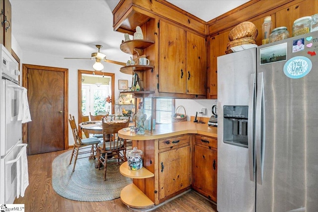 kitchen featuring wall oven, ceiling fan, stainless steel fridge, and light hardwood / wood-style floors