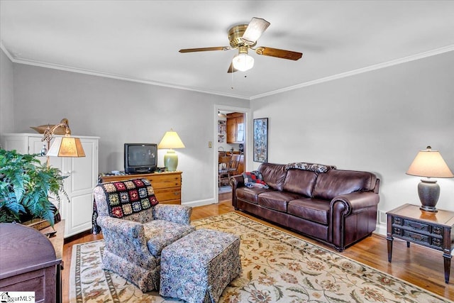 living room featuring crown molding, ceiling fan, and light hardwood / wood-style flooring