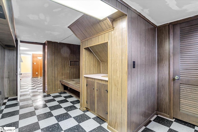 bathroom with vanity and wood walls