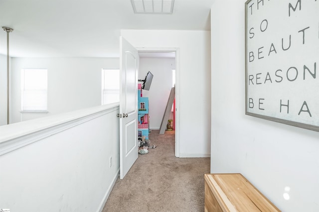 corridor featuring light colored carpet