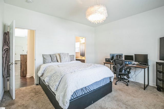 bedroom with an inviting chandelier, connected bathroom, and carpet flooring