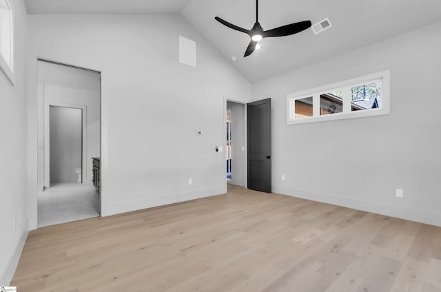 empty room with high vaulted ceiling, ceiling fan, and light hardwood / wood-style flooring