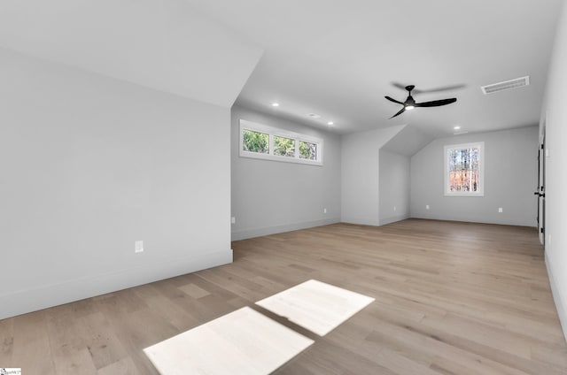 additional living space with ceiling fan, plenty of natural light, and light wood-type flooring