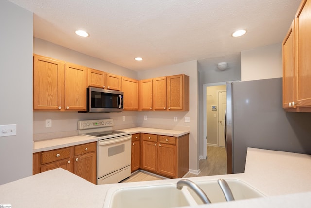 kitchen with stainless steel appliances, sink, and a textured ceiling