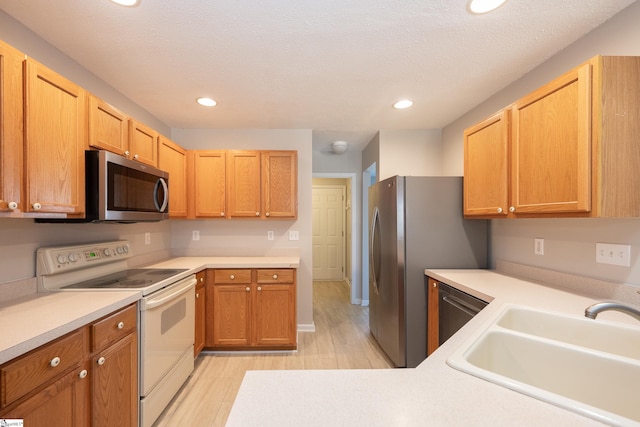 kitchen with sink, stainless steel appliances, and a textured ceiling