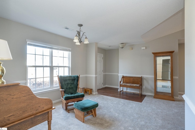 sitting room featuring carpet and a chandelier