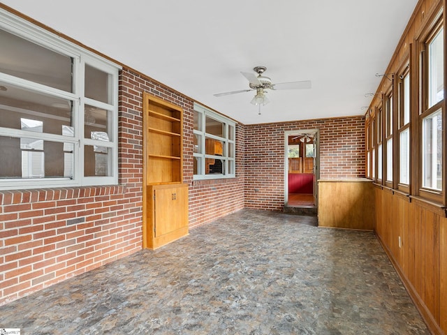 unfurnished sunroom featuring ceiling fan