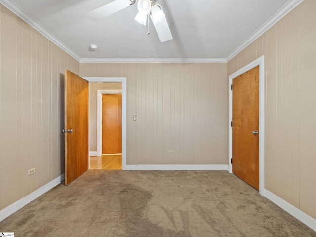 empty room with crown molding, light colored carpet, and ceiling fan