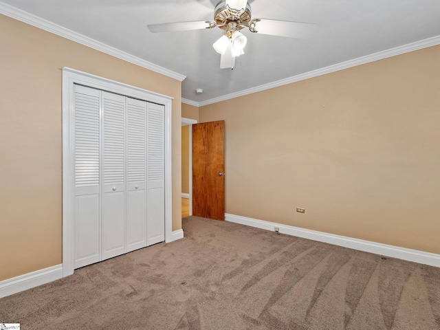 unfurnished bedroom featuring ornamental molding, a closet, ceiling fan, and carpet flooring