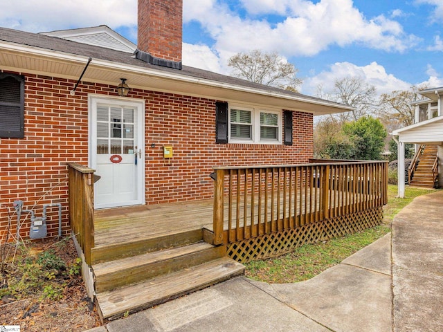 view of exterior entry featuring a wooden deck