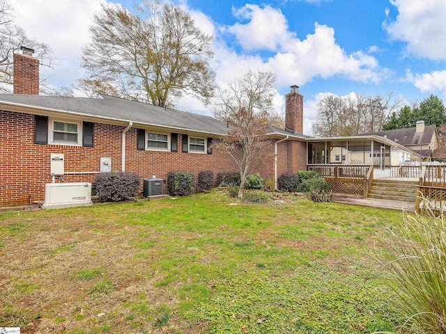 rear view of property with central AC, a yard, and a deck