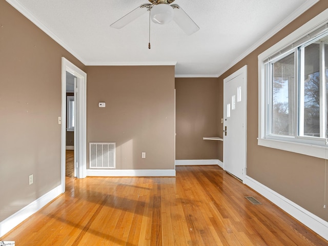 spare room featuring crown molding, wood-type flooring, and ceiling fan