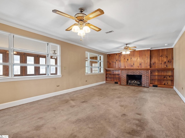 unfurnished living room with crown molding, ceiling fan, a fireplace, and carpet floors