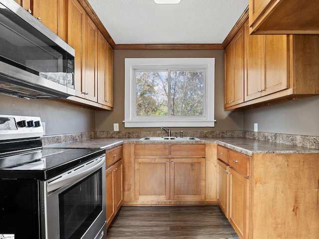 kitchen featuring appliances with stainless steel finishes, sink, a textured ceiling, and dark hardwood / wood-style flooring