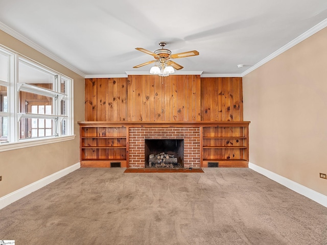 unfurnished living room with a fireplace, ornamental molding, ceiling fan, and carpet flooring