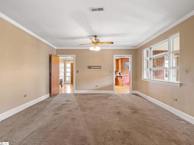 unfurnished room featuring ceiling fan, ornamental molding, and carpet flooring