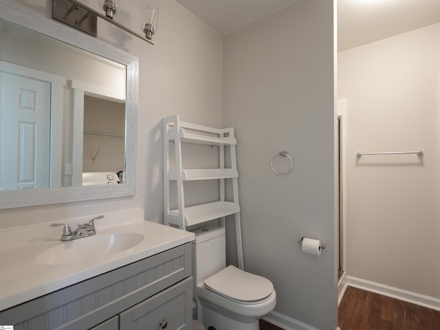 bathroom featuring hardwood / wood-style flooring, vanity, toilet, and an enclosed shower