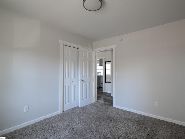 unfurnished bedroom featuring a closet and dark colored carpet