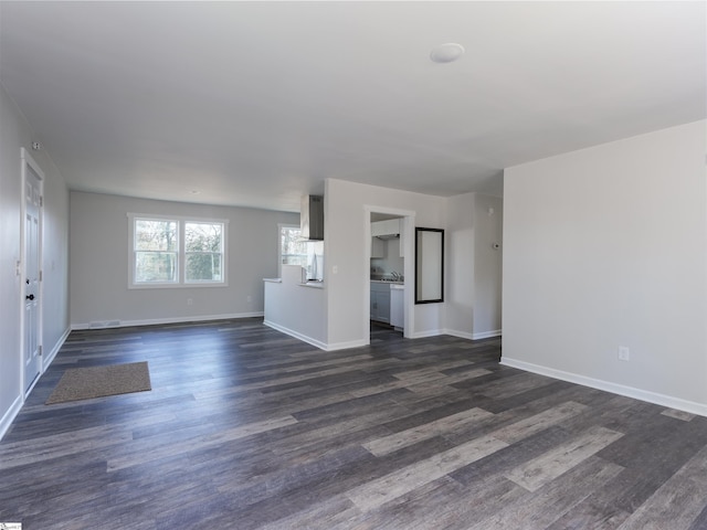 unfurnished living room with dark wood-type flooring