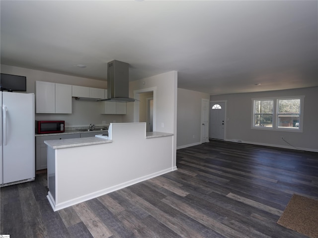 kitchen featuring white fridge, dark hardwood / wood-style floors, island range hood, and white cabinets