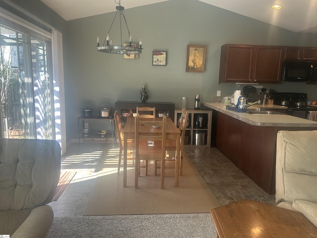 dining area featuring lofted ceiling, sink, and an inviting chandelier