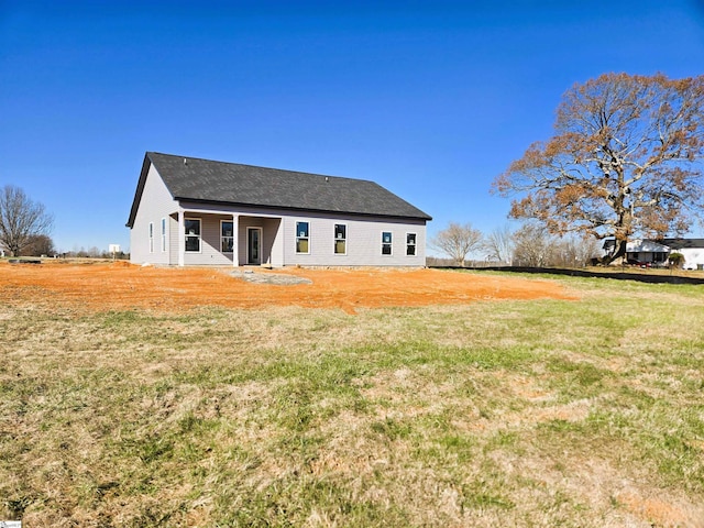 rear view of property featuring a yard