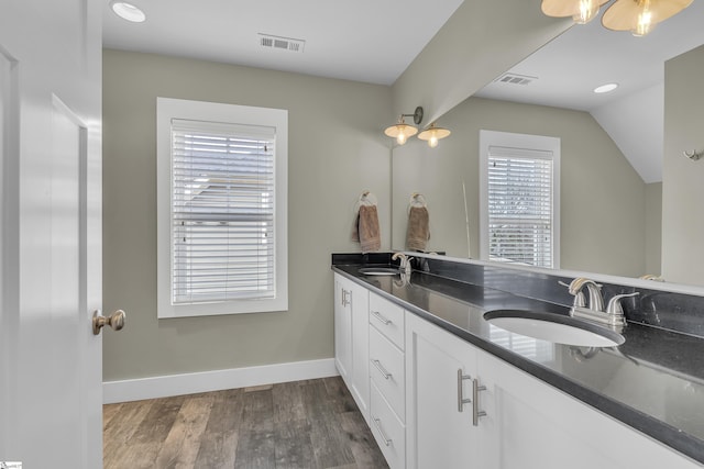 bathroom featuring hardwood / wood-style flooring, lofted ceiling, and vanity