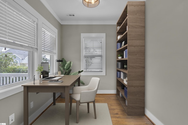 office space with crown molding and light wood-type flooring