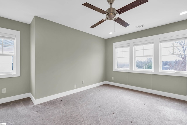 carpeted spare room featuring ceiling fan