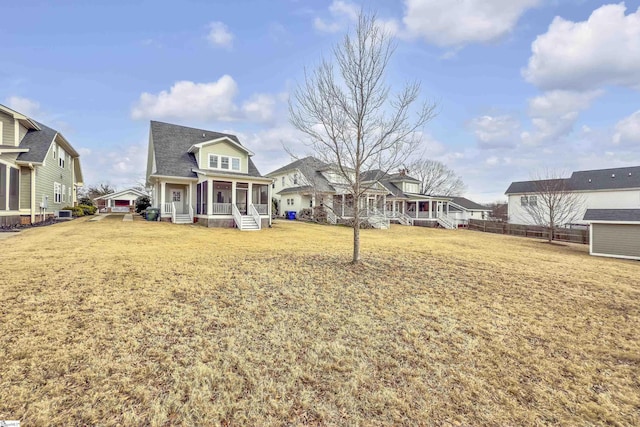 back of property with covered porch and a lawn