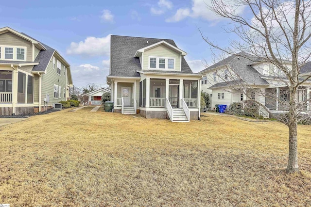 rear view of property with a yard, a sunroom, and central air condition unit