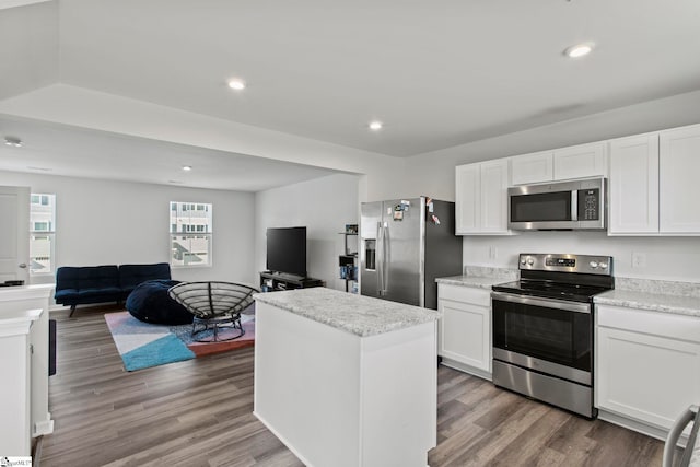 kitchen featuring stainless steel appliances, a kitchen island, dark hardwood / wood-style floors, and white cabinets