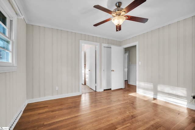 unfurnished bedroom featuring ceiling fan, crown molding, wood-type flooring, and a baseboard radiator