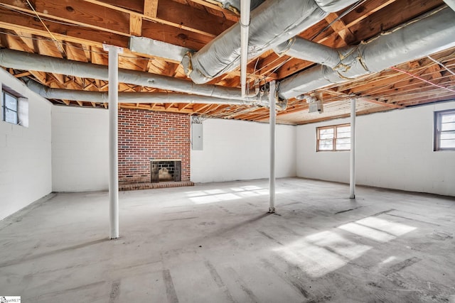 basement featuring electric panel and a brick fireplace