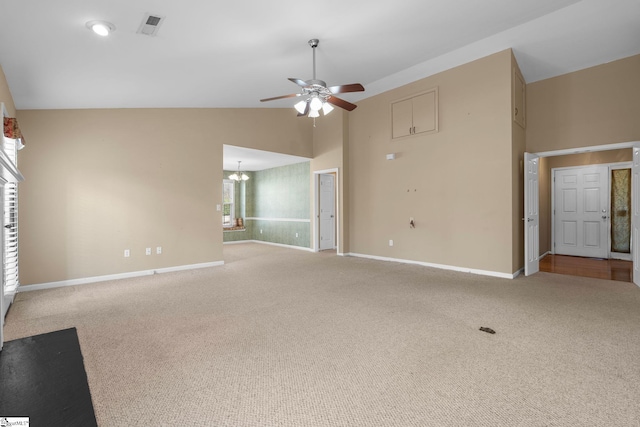 unfurnished living room with ceiling fan with notable chandelier, high vaulted ceiling, and carpet