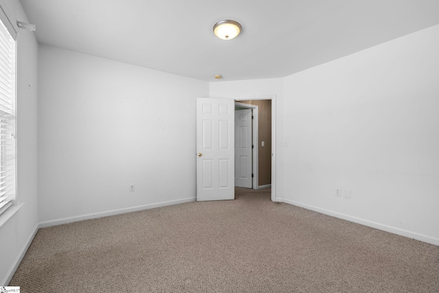 carpeted spare room featuring a healthy amount of sunlight