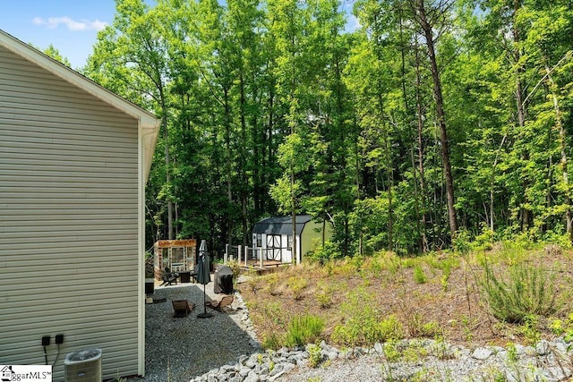 view of yard featuring a storage shed and central AC unit